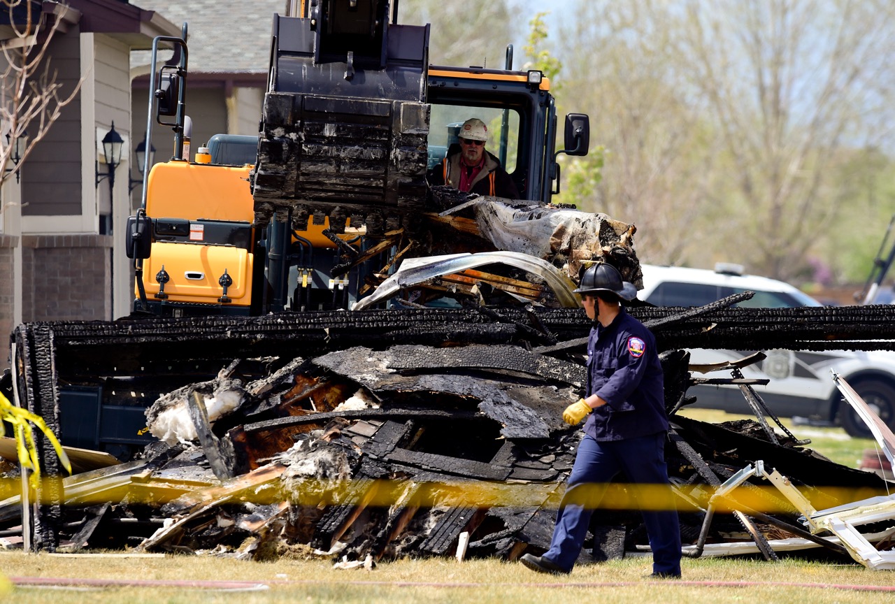 In this April 18, 2017, photo, investigators stand by as debris is removed from a house that was destroyed in a deadly explosion in Firestone, Colo., on April 17. Anadarko Petroleum said Wednesday, April 26, that it operated a well about 200 feet (60 meters) from the house in the town of Firestone. The company didn't say whether the well was believed to be a factor in the explosion or whether it produced oil, gas or both. (Matthew Jonas/The Daily Times Call via AP)